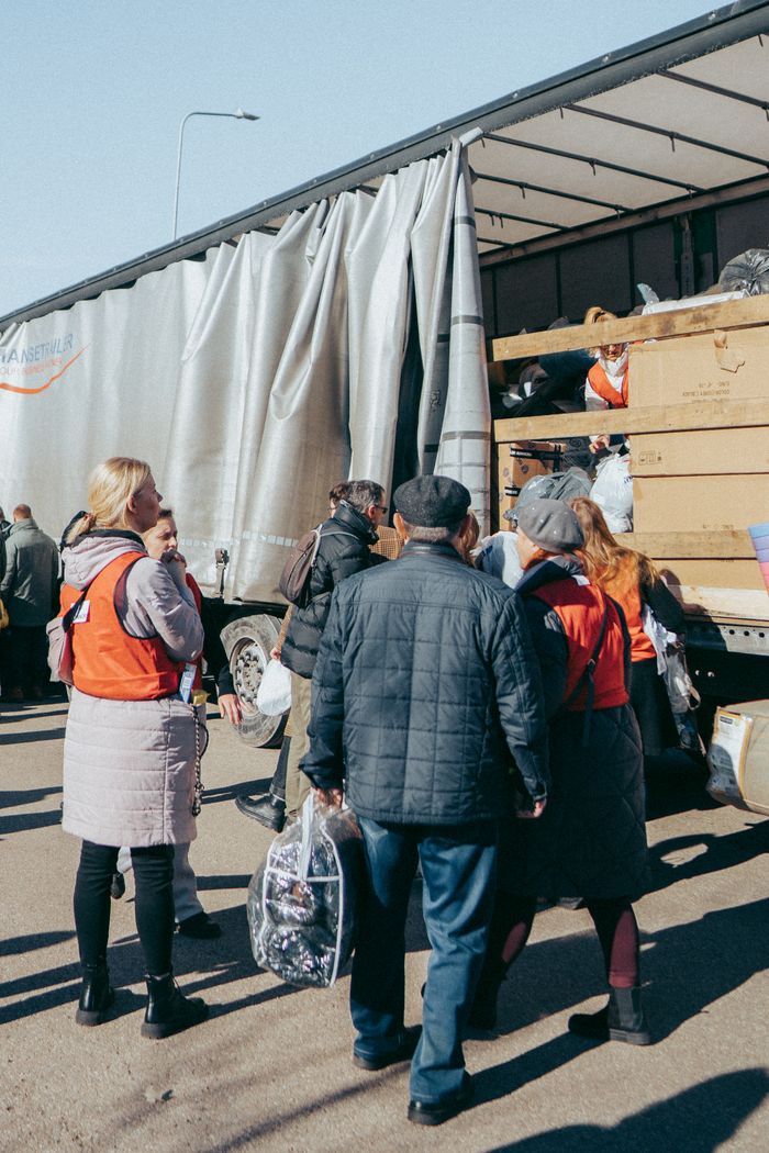 Volunteers distribute essential goods from a truck in Vilnius, Lithuania, showcasing community support.